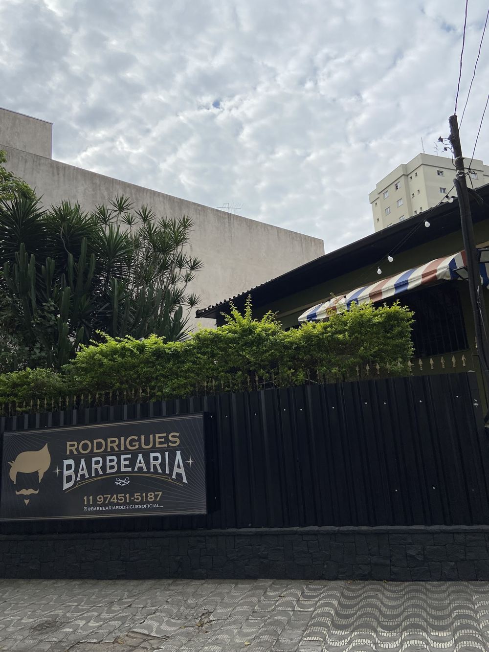 Fachada com a placa Rodrigues Barbearia