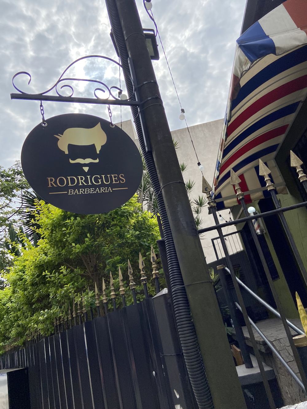 Placa pendurada da Barbearia Rodrigues na entrada